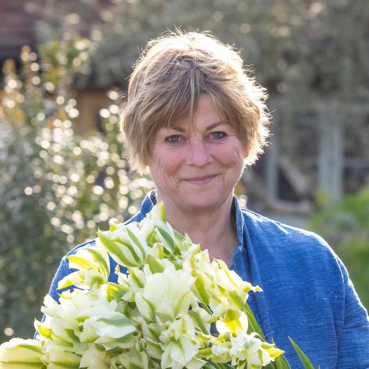 headshot of garden expert Sarah Raven holding flowers